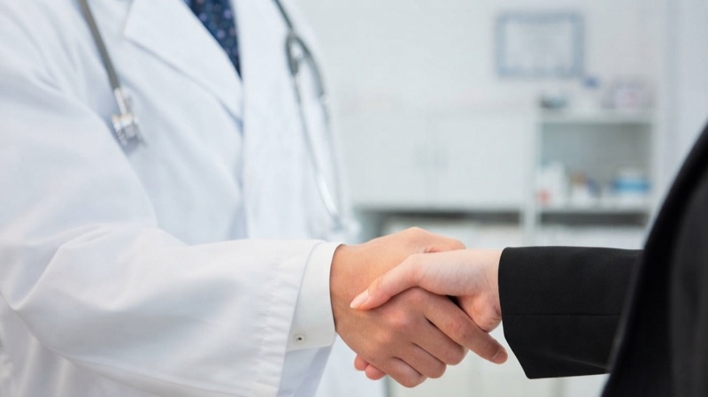 Physician shaking hands with a coordinator inside a clinic